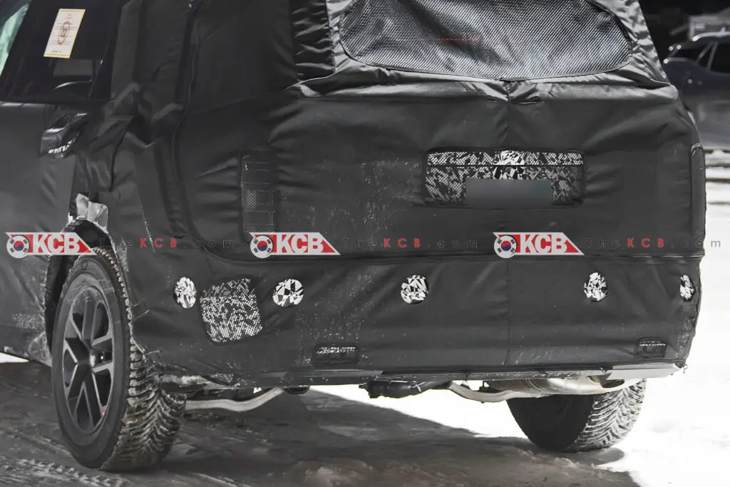 Vehículo camuflado con cubierta negra en pruebas de carretera.