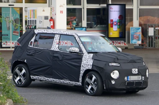 Vehículo camuflado, probablemente un prototipo de coche, en la calle.