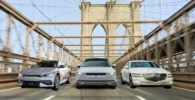 Tres coches modernos circulando en el Puente de Brooklyn.