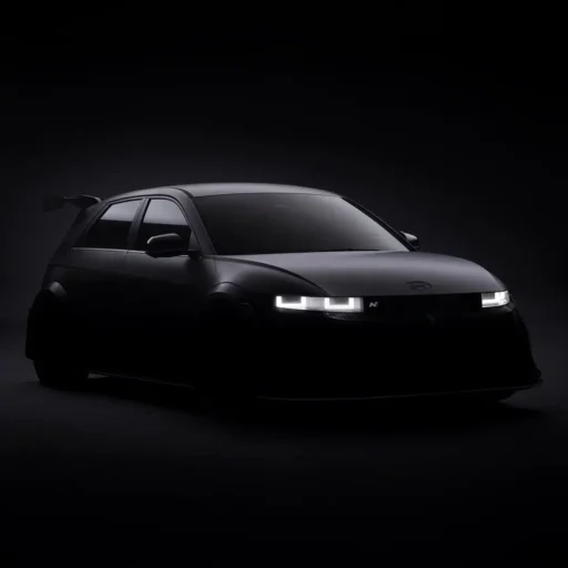 Automóvil deportivo negro en iluminación tenue y fondo oscuro.