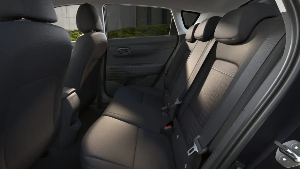 Interior de un vehículo, asientos traseros, vista desde puerta abierta.