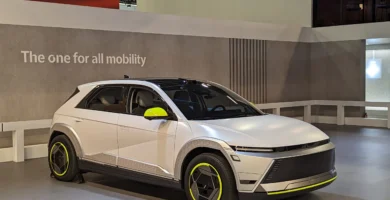 Automóvil futurista blanco exhibido en una feria de autos.