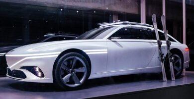 Automóvil blanco futurista con puertas de ala de gaviota exhibido.