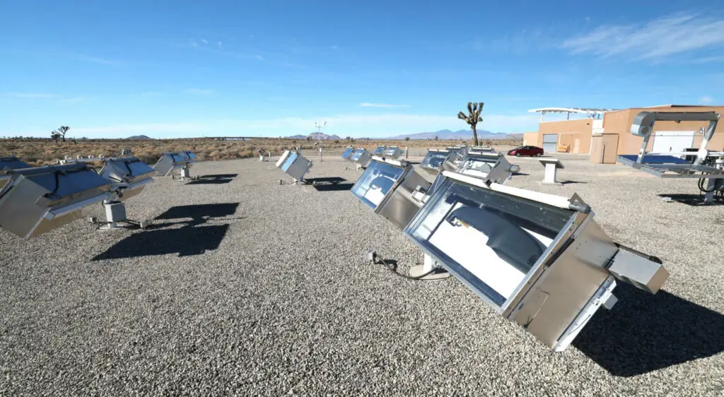 Campo de cocina solar con hornos parabólicos al aire libre.