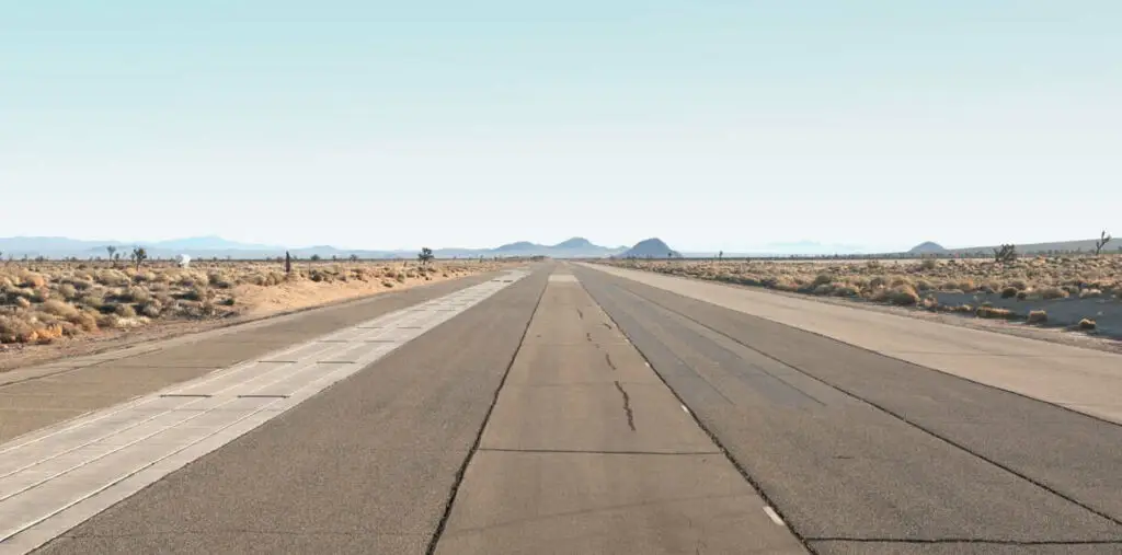 Carretera desolada en un desierto con cielo claro.