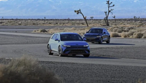 Dos automóviles modernos conduciendo en un desierto árido.